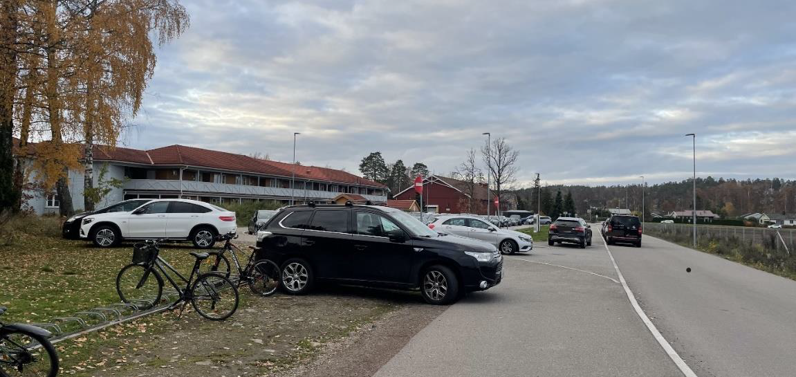Bilde av bilder som står parkert ved sykkelstativ og på fortauet. - Klikk for stort bilde